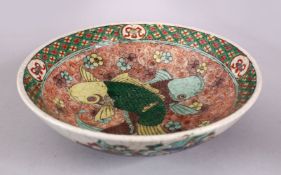 A CHINESE FAMILLE VERTE PORCELAIN TWIN FISH / WARRIOR BOWL, the interior decorated with twin fish