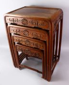 A CHINESE CARVED HARD WOOD NEST OF TABLES. comprising four graduating sized tables, the frieze