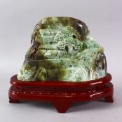 A LARGE CHINESE JADE STONE LANDSCAPE CARVING, depicting a native landscape built upon a