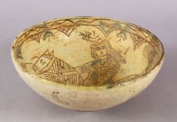 A GOOD IRAN STYLE POTTERY BOWL, decorated with green & biscuit grounds depicting a figure upon horse