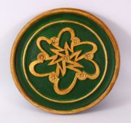 A TURKISH ISLAMIC CARVED WOODEN CIRCULAR WRITING PANEL, with a green base and raised gilded floral
