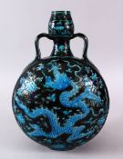 A CHINESE MING STYLE FAHUA PORCELAIN MOON FLASK, carved with dragons in blue upon a black ground,