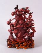 A CHINESE CARVED PINK & BLACK RHODONITE VASE & COVER, carved in relief with berry flora, the top