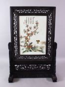 A CHINESE CARVED HARDWOOD & PORCELAIN FAMILLE ROSE SCREEN, the wooden frame carved in openwork