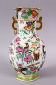 A CHINESE CANTON FAMILLE ROSE PORCELAIN VASE, decorated upon a white ground with floral and bird