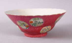 A CHINESE PINK GROUND FAMILLE ROSE PORCELAIN BOWL, decorated with roundel of flora, the base with