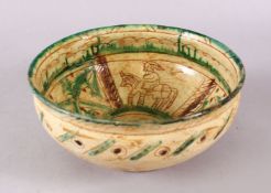 A GOOD IRAN STYLE POTTERY BOWL, decorated with green & biscuit grounds with carved figures upon