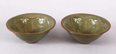A PAIR OF SONG STYLE CELADON CARVED POTTERY TEA CUPS - carved with flora 10cm