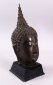 A THAI BRONZE FIGURE OF A HEAD, upon a fitted stand, 36cm high