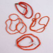 A MIXED LOT OF FOUR CHINESE CARVED RED NECKLACES, possibly coral.