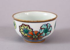 A SMALL CHINESE DOUCAI PORCELAIN TEA CUP, with floral decoration and a gilded rim, the base with a