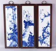 A SET OF THREE CHINESE FRAMED BLUE & WHITE PORCELAIN PANELS, each with a varyied display of native