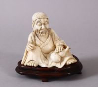 A FINE 19TH CENTURY CHINESE CARVED IVORY FIGURE OF AN IMMORTAL, in a seated position holding a