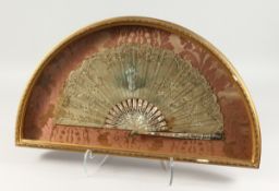 AN 18TH CENTURY FRENCH MOTHER-OF-PEARL AND LACE FAN in a glass case, decorated with a young girl and