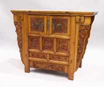 A CHINESE ALTAR TABLE with plain top carved front cupboard doors and drawers, 3 ft. 7 in. long, 1
