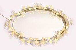AN OVAL BEVELLED MIRROR with four light holders, scrolling leaf frame with cut glass beads, 3 ft x 2