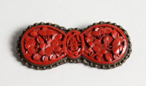 A CHINESE CINNABAR LACQUER BROOCH.