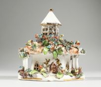 A STAFFORDSHIRE FLOWER ENCRUSTED COTTAGE. 5 ins long.