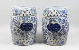 A PAIR OF CHINESE BLUE AND WHITE BARREL SEATS with scrolls, 17 ins high