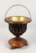 A CONTINENTAL CIRCULAR SHAPED MAHOGANY JARDINIERE with brass liner 15 ins diameter x 16 ins high.