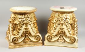 A GOOD PAIR OF CREAM AND GILDED STANDS with circular tops and scrolling acanthus, 1 ft. 4 in. high.