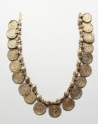 AN ISLAMIC METAL NECKLACE hung with seventeen medallions, 17 inches long