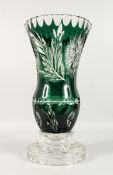 A LARGE BOHEMIAN GREEN CUT GLASS VASE on a plain circular base. 18.5ins high.