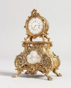 A MINIATURE GILDED CLOCK, rococo case with painted panel, 7 inches high