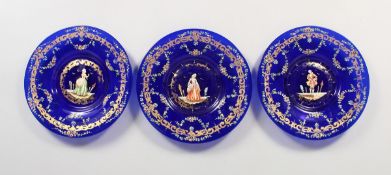 A SET OF THREE VIENNA BLUE GLASS PLATES, the centre with figures 7.5 ins diameter.
