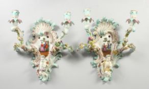 A GOOD PAIR OF MEISSEN PORCELAIN TWO LIGHT WALL SCONCES with cupid and encrusted with flowers and