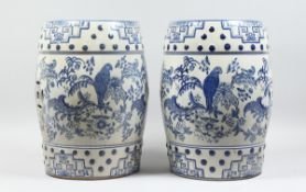 A PAIR OF CHINESE BLUE AND WHITE BARREL SEATS with birch and flowers 17 ins high