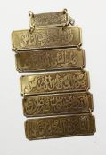 SIX ISLAMIC METAL TABLETS strung together with calligraphy.
