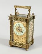 A 19TH CENTURY FRENCH BRASS CARRIAGE CLOCK with filigree face and coloured sides. 6ins.