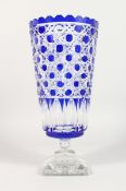 A CUT BLUE CRYSTAL BOHEMIAN TAPERING VASE on square stand. 13ins high.