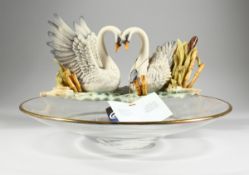 A GLASS CIRCULAR CENTREPIECE with two porcelain swans, 1 ft. 2 in.