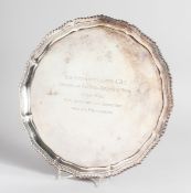 A PIE CRUST SILVER SALVER with gadrooned edge on four knurled feet presented to Sir Anthony Lewis,