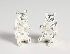 A PAIR OF 800 SEATED PIGS SALT AND PEPPERS