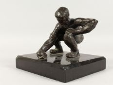 JUGANDO CANICAS (MEXICAN) A BRONZE CROUCHING MAN. Signed, on a black marble base. 5ins high.