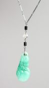 A CARVED JADE PENDANT on a chain.