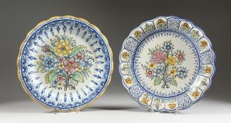 TWO POTTERY DISHES painted with flowers, 13 in. diameter.