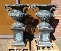 A LARGE PAIR OF BLACK STONE MARBLE ELVES TWO HANDLED URNS ON STANDS 4 ft 10 ins high