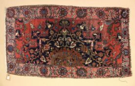 A SMALL PERSIAN RUG, red ground with birds and floral decoration. 4 ft. 4 ins x 2ft. 6ins.