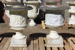 A SUPERB NEAR PAIR OF ITALIAN CARVED WHITE MARBLE URNS ON STANDS, the sides covered with dancing