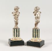 A SUPERB SMALL PAIR OF SILVERED BRONZE AND ENAMEL CUPIDS ON STANDS 6 ins high.