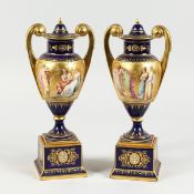 A SUPERB PAIR OF VIENNA TWO HANDLED VASES AND COVERS, rich blue and gilt grounds, painted with a