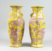 A PAIR OF YELLOW DRAGON DESIGN OCTAGONAL VASES 17 ins high.