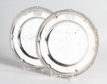 A PAIR OF GEORGE III CAST SILVER DINNER PLATES with gadrooned edges, 10 ins diameter, crested,