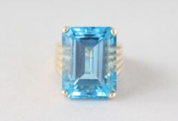 A LARGE GOLD BLUE TOPAZ RING.