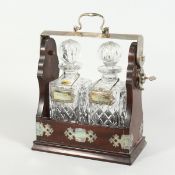 A TWO BOTTLED WHISKY DECANTER AND STOPPERS in a tantalus