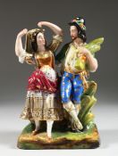 A 19TH CENTURY PORCELAIN GROUP, young man carrying a sheaf of corn with girl dancing, 9 inches